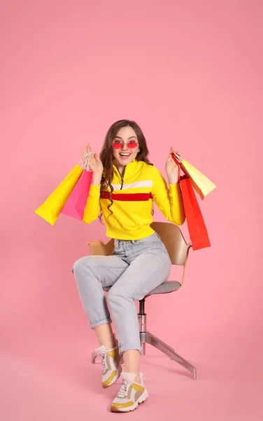 Emotionele Vrouw Stijlvolle Zonnebril Met Veel Kleurrijke Boodschappentassen Fauteuil Tegen — Stockfoto