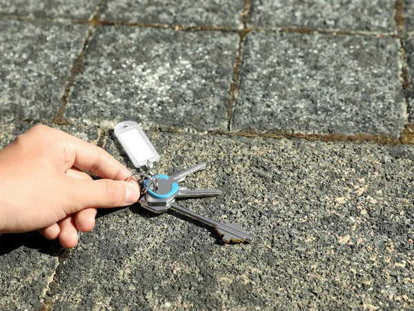 stock image Woman picking bunch of keys from pavement outdoors, closeup. Space for text