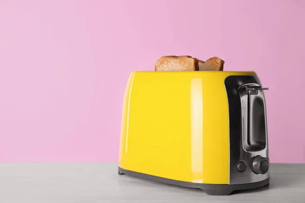 现代烤面包机与切片烤面包在白色木制桌子上 案文的篇幅 — 图库照片