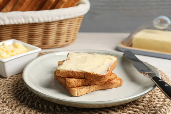 stock image Tasty toasts served with butter on white wooden table