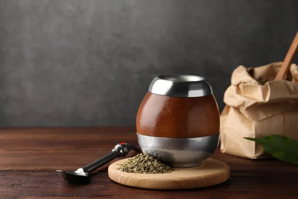 stock image Calabash with mate tea and bombilla on wooden table. Space for text