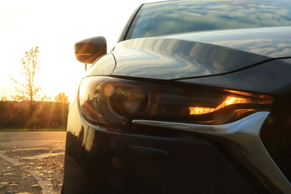 Μαύρο Σύγχρονο Αυτοκίνητο Σταθμευμένο Στο Δρόμο Κατά Ηλιοβασίλεμα Closeup Του — Φωτογραφία Αρχείου