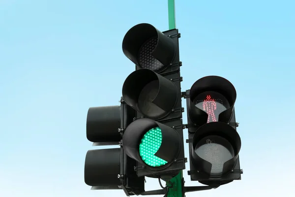 青い空に対して赤と緑の信号を持つ信号機 — ストック写真