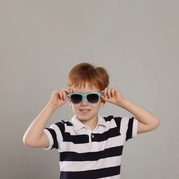 Cute Little Boy Okularach Przeciwsłonecznych Jasnoszarym Tle — Zdjęcie stockowe