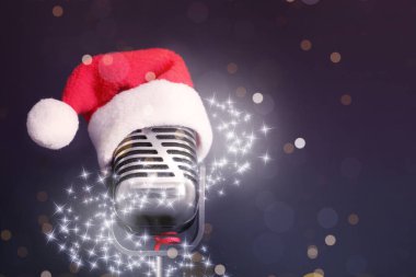 Siyah arka planda Noel Baba şapkalı Retro mikrofon, mesaj için boşluk. Noel müziği