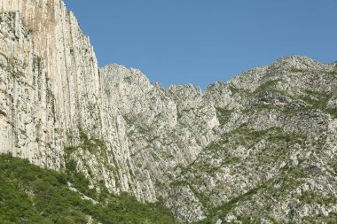 Açık havada mavi gökyüzünün altında yüksek dağları olan resim gibi bir manzara.