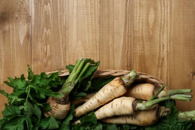 Tahta masada hasır sepetin içinde taze taze, taze yaban havucu. Metin için boşluk