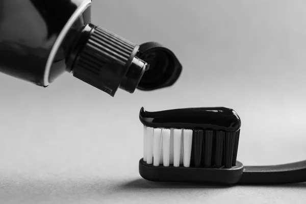 Applying Charcoal Toothpaste Brush Light Grey Background Closeup — Stock Photo, Image