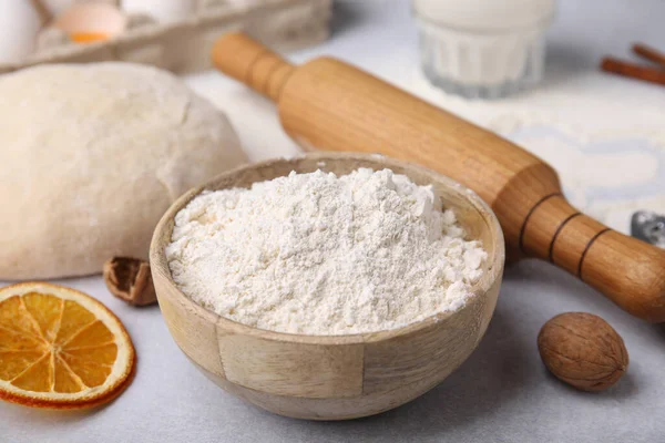 stock image Bowl of flour, rolling pin and ingredients on white table