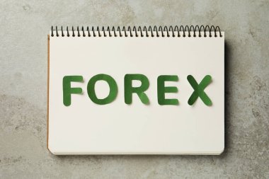Sözcüklü defter Gri masa üzerinde yeşil harflerden oluşmuş Forex düz yatıyordu