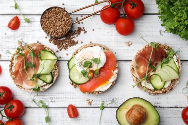 Beyaz ahşap masa üzerinde farklı malzemeli gevrek karabuğday kekleri.