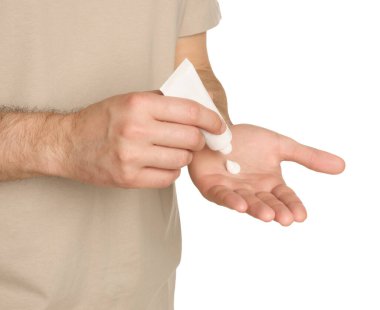 Man applying cream onto hand against white background, closeup