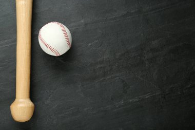 Siyah arkaplanda beysbol sopası ve top, yazı için yeri olan üst manzara. Spor malzemeleri.