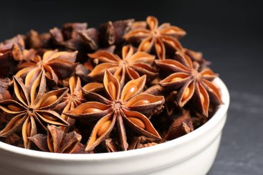 Koyu renkli masada aromatik anason yıldızlı kase, yakın plan.