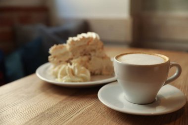 Lezzetli bir tatlı ve kafedeki ahşap masada taze aromatik kahve.