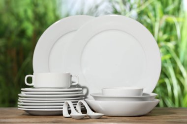 Ahşap masada bulanık arka plana karşı temiz bulaşık takımı