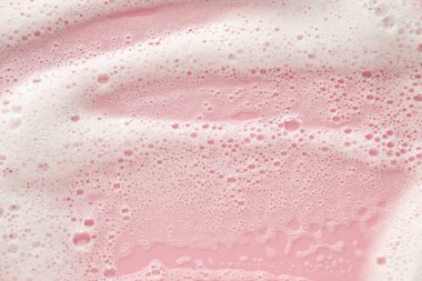 Soluk pembe arka planda beyaz yıkama köpüğü, üst manzara