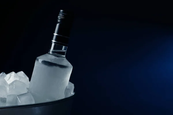 暗い背景の氷と金属バケツのウォッカのボトル テキストのスペース — ストック写真