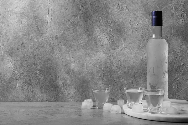 Bir Şişe Votka Gri Duvarda Buz Küpleri Olan Shot Bardakları — Stok fotoğraf