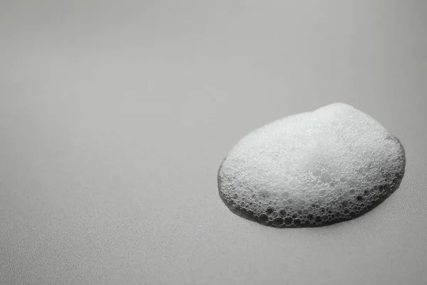 灰色の背景にふわふわの石鹸泡のドロップ テキストのスペース — ストック写真