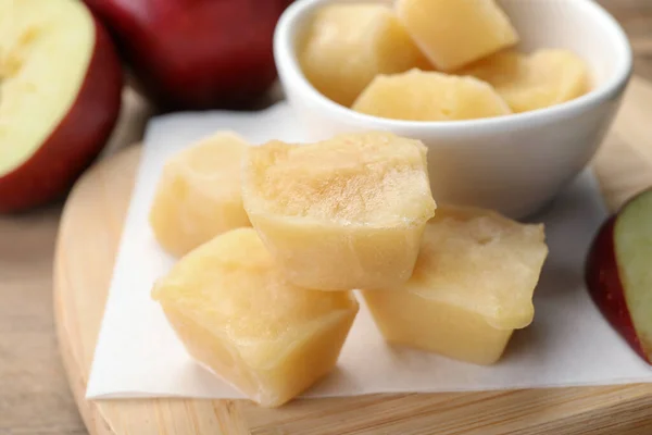 Frozen apple puree cubes and ingredient on wooden table, closeup