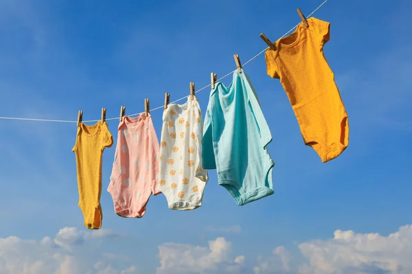 Temiz Bebek Tulumları Gökyüzüne Karşı Çamaşır Ipine Asılı Kuru Giysiler — Stok fotoğraf