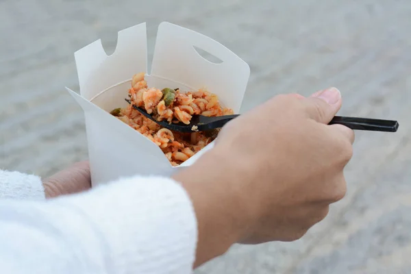 stock image Woman eating takeaway noodles from paper box with fork outdoors, closeup. Street food