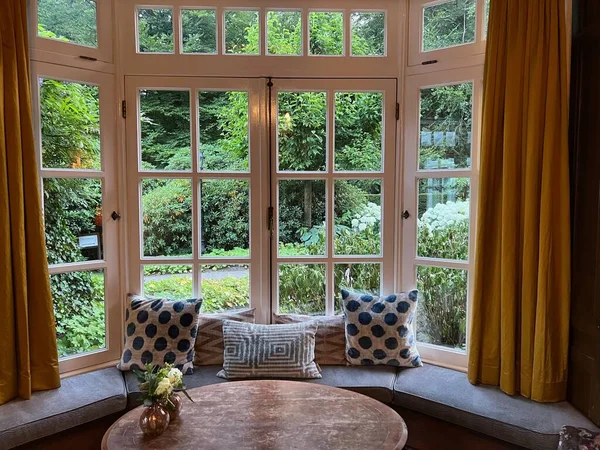 Drewniany Stół Przy Oknie Wnękowym Poduszkami Przytulnym Pokoju Projekt Wnętrza — Zdjęcie stockowe