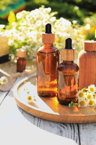 Bottles Essential Oil Flowers White Wooden Table Outdoors — Foto Stock