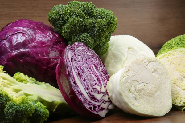 stock image Different types of cabbage on wooden table, closeup