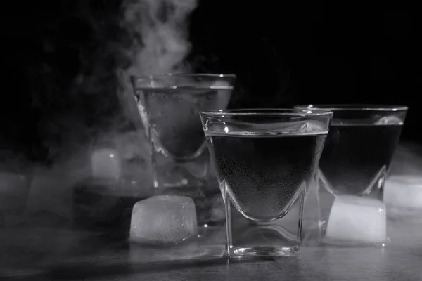 Vodka Bicchierini Con Ghiaccio Sul Tavolo Sullo Sfondo Nero — Foto Stock