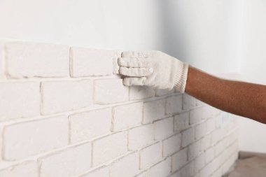 İşçi odaya dekoratif duvar kiremitleri yerleştiriyor, yakın plan