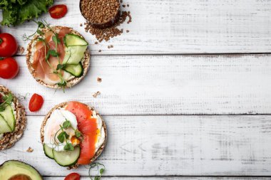 Beyaz ahşap masa üzerinde farklı malzemeli gevrek karabuğday kekleri, düz yatak. Metin için boşluk