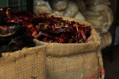 Çuval bezinde kurutulmuş guajillo biberi yığını, yakın plan.