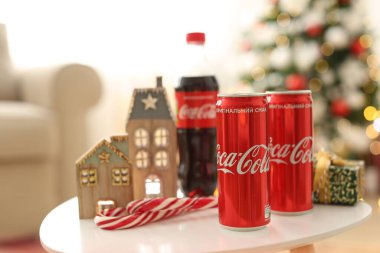 MYKOLAIV, UKRAINE - 15 Ocak 2021: Coca-Cola kutuları ve hediye kutusunun yanında Noel dekoruyla birlikte şişe