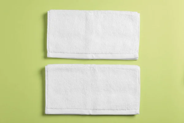 柔らかい緑の背景に白いタオルを折り フラットレイアウト — ストック写真