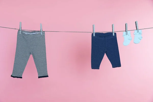 Different Baby Clothes Drying Laundry Line Pink Background — Stok fotoğraf