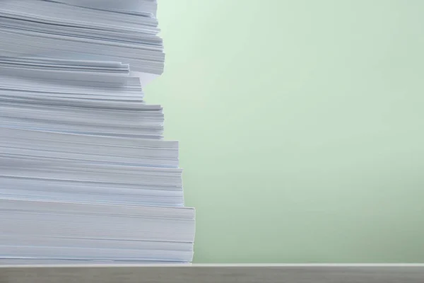 stock image Stack of paper sheets on white table against light green background, closeup. Space for text