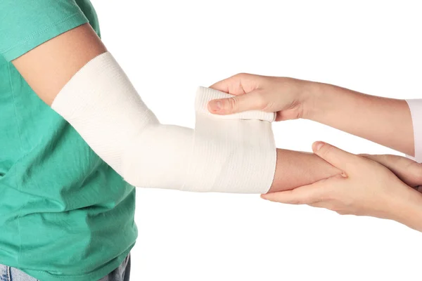 白い背景に患者の腕に包帯を適用する医師 クローズアップ — ストック写真