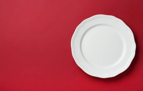 红色背景的洁白的盘子 顶视图 案文的篇幅 — 图库照片