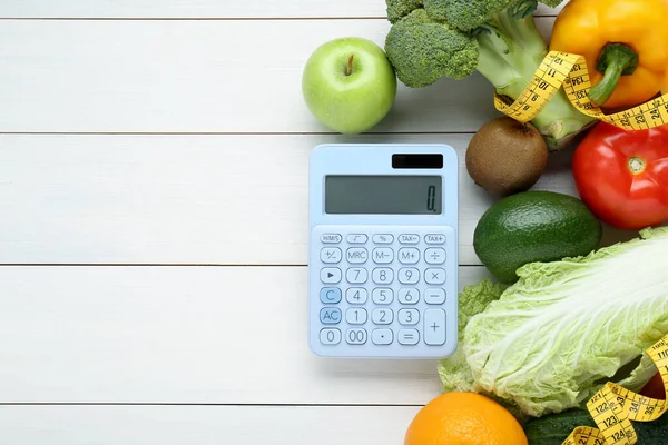 Calculator and food products on white wooden table, flat lay with space for text. Weight loss concept