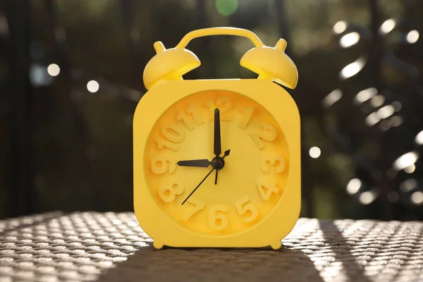 天気の良い朝 屋外のテーブルの上に黄色の目覚まし時計 — ストック写真