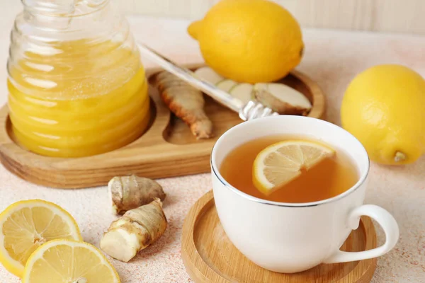 Tea, honey, lemon and ginger on beige textured table