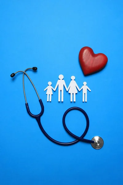 Stock image Paper family cutout, stethoscope and red heart on light blue background, flat lay. Insurance concept