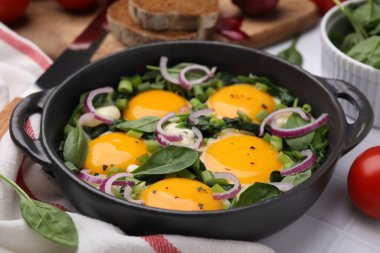 Lezzetli Shakshouka beyaz masada servis yapıyor, yakın plan.