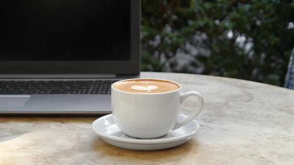 Filiżanka Pysznej Kawy Laptop Beżowym Marmurowym Stole Zewnątrz — Zdjęcie stockowe
