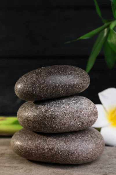 Gestapelte Wellness Steine Bambus Und Blume Auf Holztisch Nahaufnahme — Stockfoto