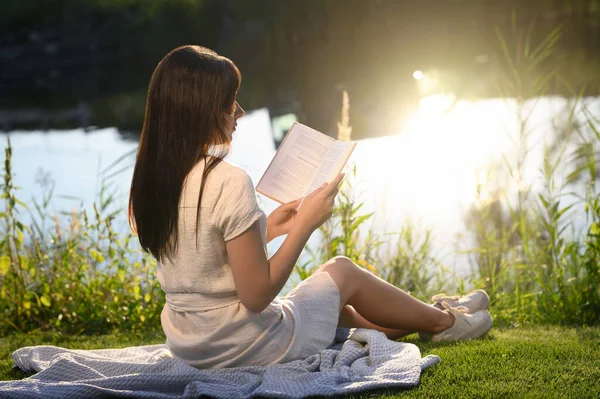 Νεαρή Γυναίκα Διαβάζει Βιβλίο Κοντά Στη Λίμνη Την Ηλιόλουστη Μέρα — Φωτογραφία Αρχείου