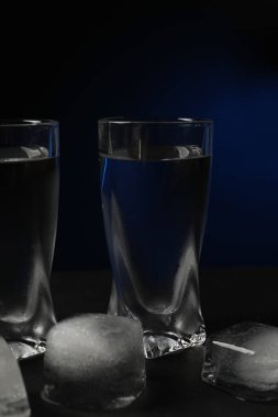 Siyah masada buzlu bir bardak votka, siyah arka planda, yakın planda.