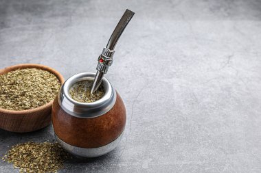 Bombilla soslu Calabash ve gri masada çay yaprakları, mesaj için yer.